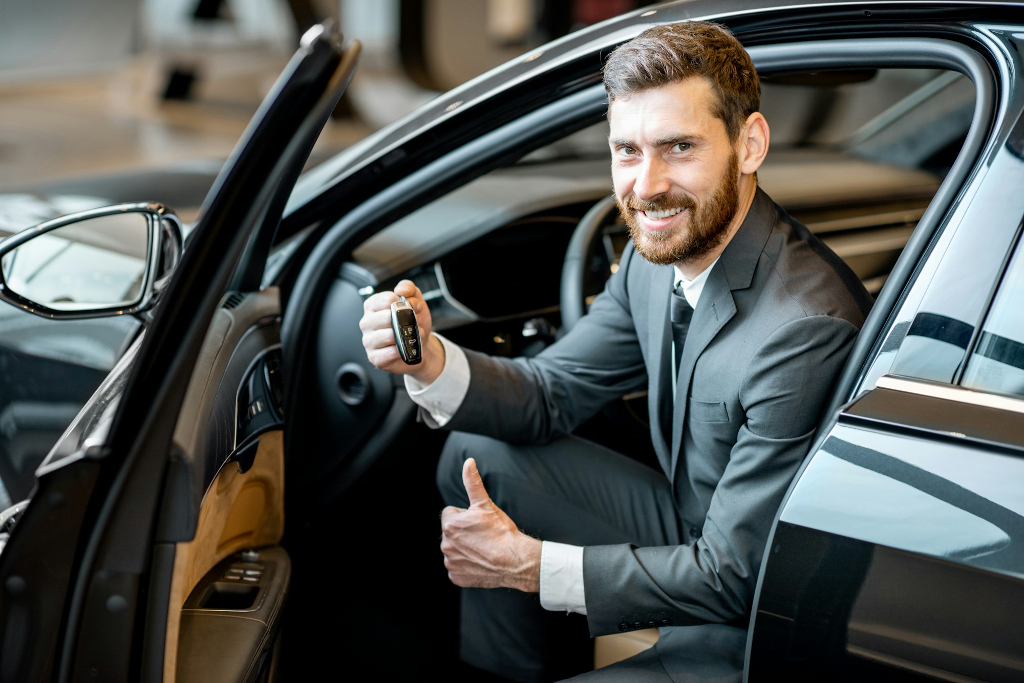 Businessman in the luxury car at the showroom